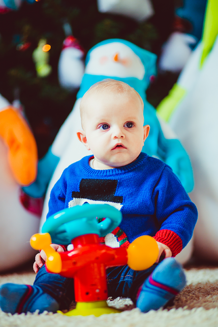 toddler in blue with a toy steering wheel